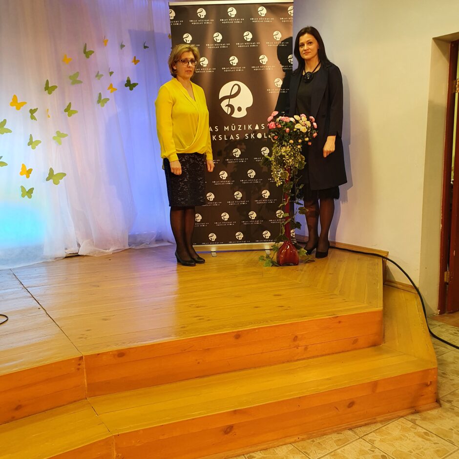 Vokālās mūzika - Kora klases pedagogi L.Krūmiņa un I.Ozoliņa pie skolas jaunā logo