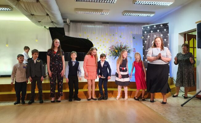 Uz skatuves kopā visi flautas spēles un klavierspēles audzēkņi, ar ped. S.Lukšvicu un B.Kvalbergu