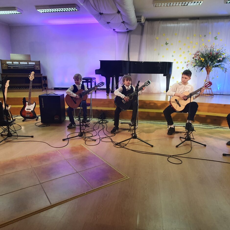 Uz skatuves muzicē 5 ģitāras spēles 1. klases audzēkņi