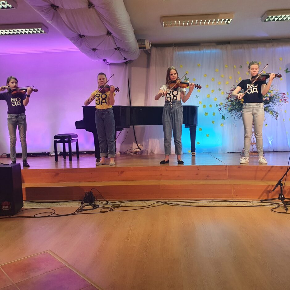 Uz skatuves muzicē vijoles spēles audzēkņu ansamblis