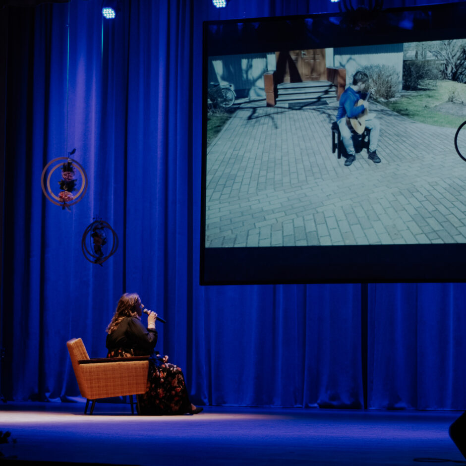 Rojas MMS 55 gadu jubilejas koncertā muzicē S.Lukševica, fonā video ar skolu